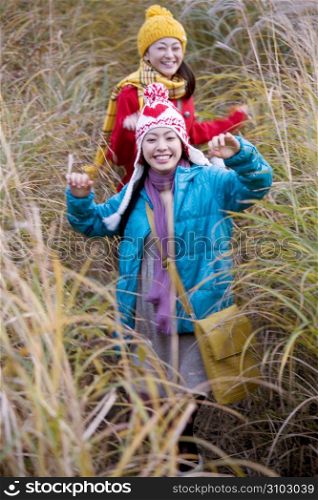 Smiling Japanese teenage girls in a field