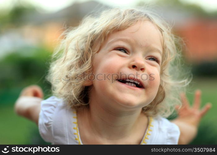 Smiling kid in summer park. Shallow depth of field