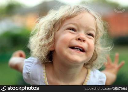 Smiling kid in summer park. Shallow depth of field