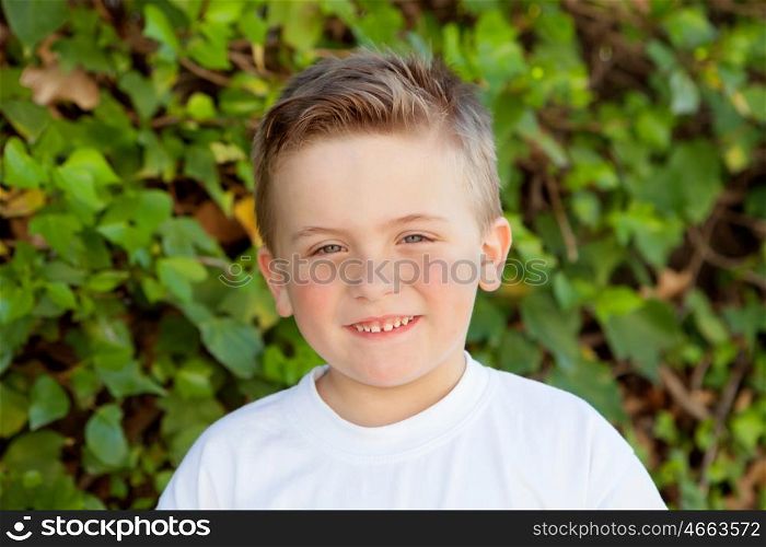 Smiling kid with blue eyes about 5 years in the garden
