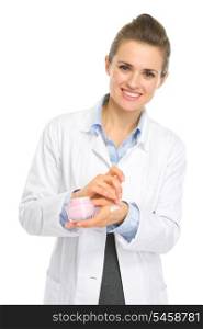 Smiling kosmetist woman applying creme on hand