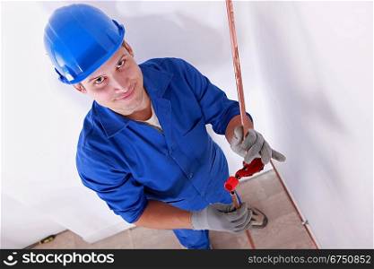 Smiling laborer installing piping