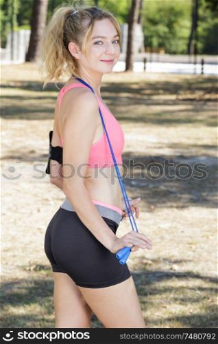 smiling lady having rest during exercising with jumping ropes