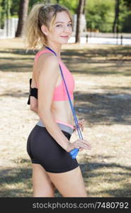 smiling lady having rest during exercising with jumping ropes