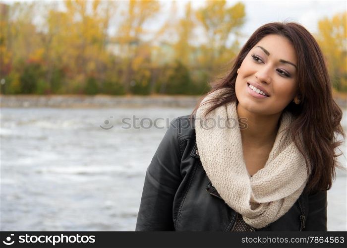 Smiling Latino woman posing outdoors during fall