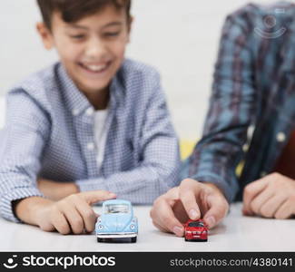 smiling little boy playing with toy cars