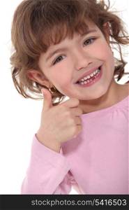 Smiling little girl giving the thumbs up