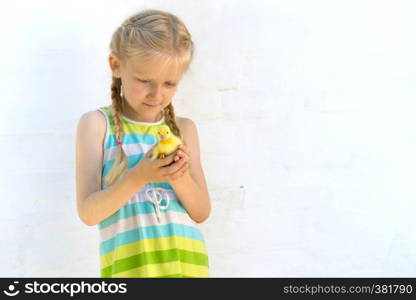 smiling little girl holding a little duckling