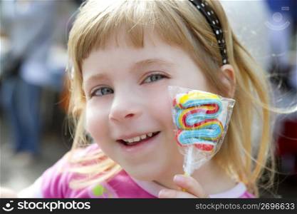 smiling little girl with lollipop sweet in hand outdoors portrait