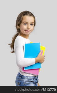 Smiling little student girl holding notebooks