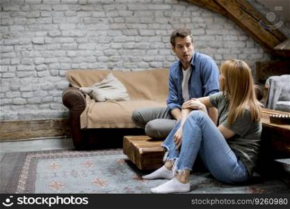Smiling lovely young couple relaxing and watching TV at rustic home