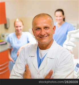 Smiling male dentist posing with female assistants at office