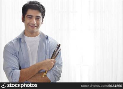 Smiling male painter holding paintbrush