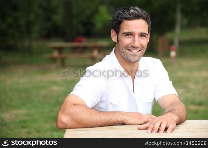 Smiling man at a park bench