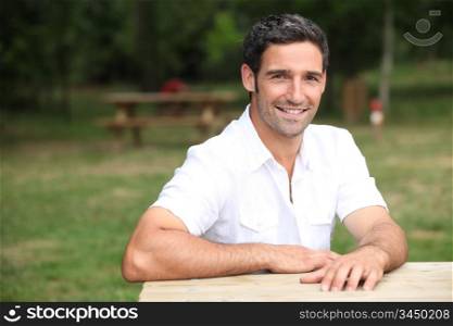 Smiling man at a park bench