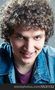 Smiling man closeup. Portrait of a young caucasian guy with curly hair