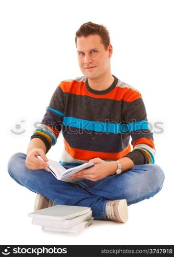 Smiling man college student sitting and reading book studying for exam isolated. Studio shot.
