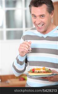 Smiling man eating a fruit flan