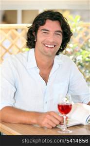 Smiling man enjoying a glass of rose