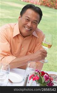Smiling Man Enjoying a Glass of White Wine
