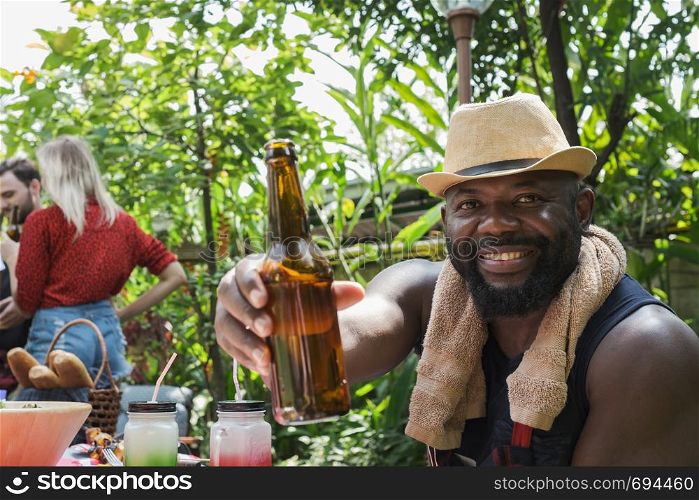 Smiling man holding beer for dinner camping in nature outdoor as summer lifestyle