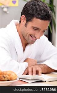smiling man in robe reading