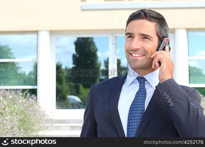 Smiling man in suit talking on cellphone