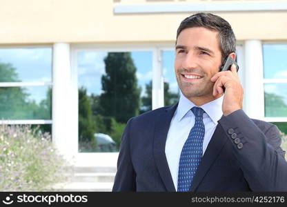 Smiling man in suit talking on cellphone