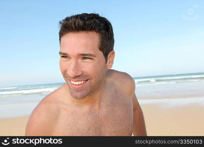 Smiling man jogging on a sandy beach