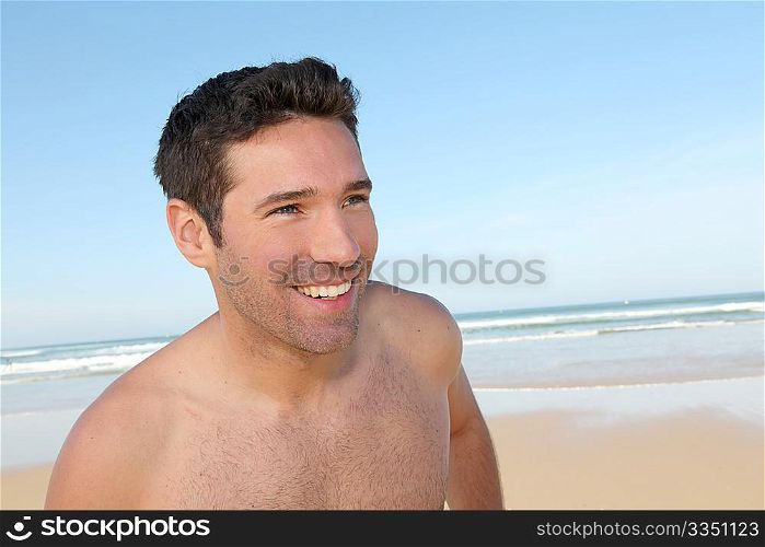 Smiling man jogging on a sandy beach