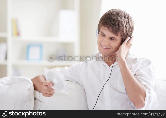 Smiling man listening to music and sees the disc
