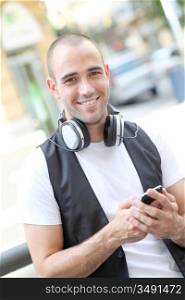 Smiling man listening to music in the street