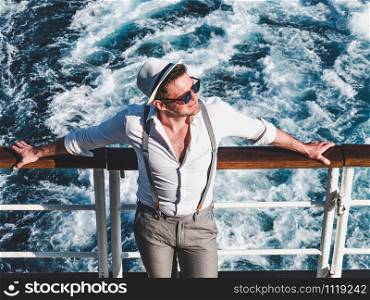Smiling man on the empty deck of a cruise liner on the background of sea waves. Top view, close-up. Concept of leisure and travel. Smiling man on the empty deck of a liner