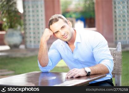 Smiling man seated at a table in a cafe