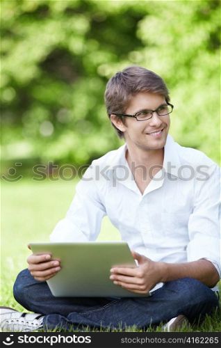 Smiling man sitting in a park