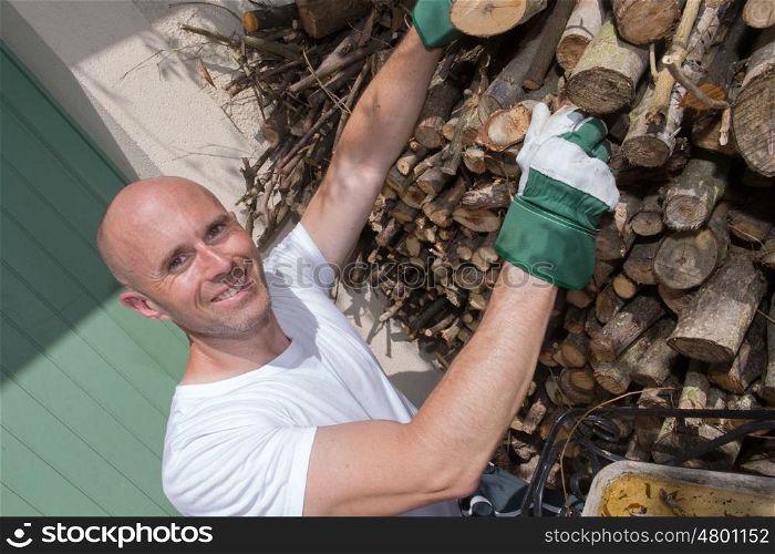 smiling man tidying up wood logs