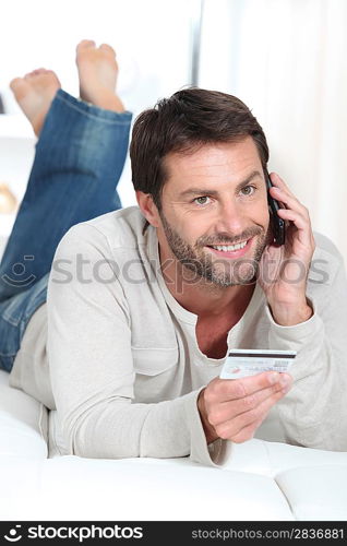 Smiling man using a credit card