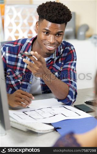 smiling man using laptop sitting at home office desk