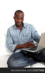 Smiling man websurfing on laptop computer at home