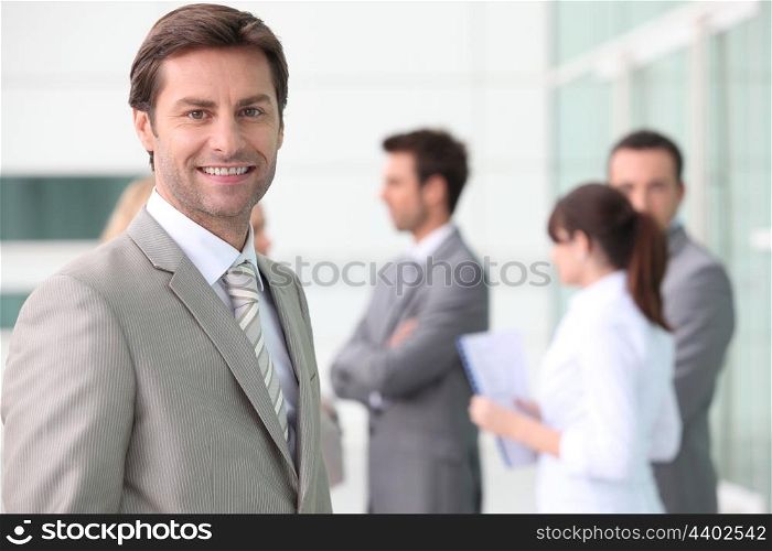 Smiling man with colleagues outside office building