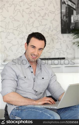smiling man with laptop indoors