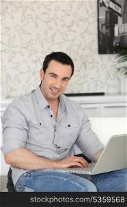 smiling man with laptop indoors