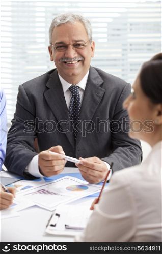 Smiling mature businessman in discussion with female executives