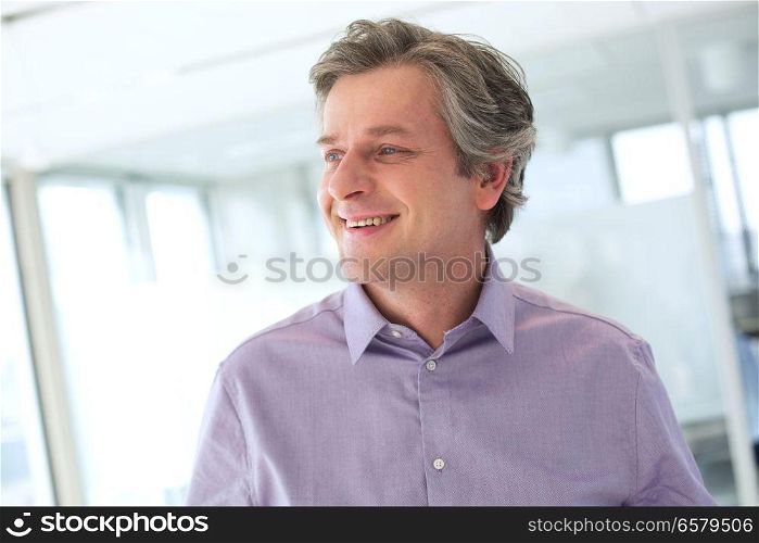 Smiling mature businessman looking away at office