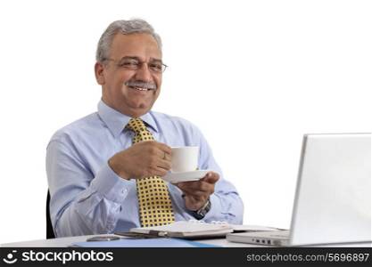 Smiling mature businessman on coffee break