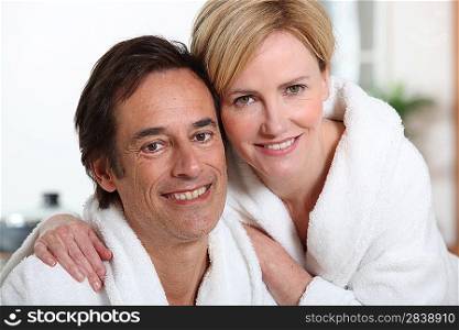 Smiling mature couple in bathrobes