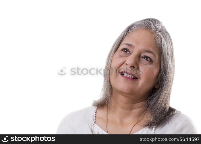 Smiling mature woman looking away over white background