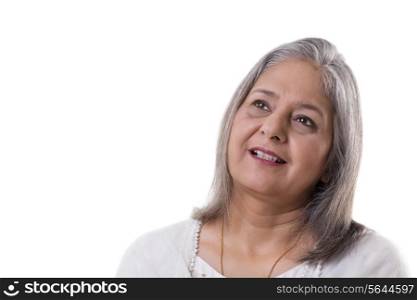 Smiling mature woman looking away over white background