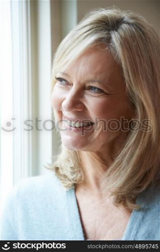Smiling Mature Woman Looking Out Of Window