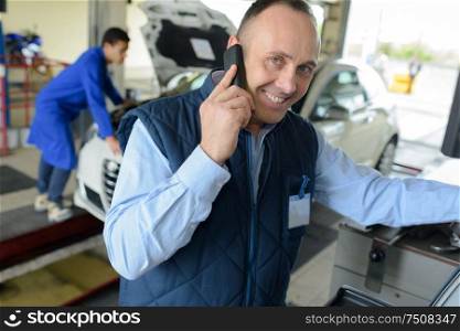 smiling mechanic on the phone at the repair garage